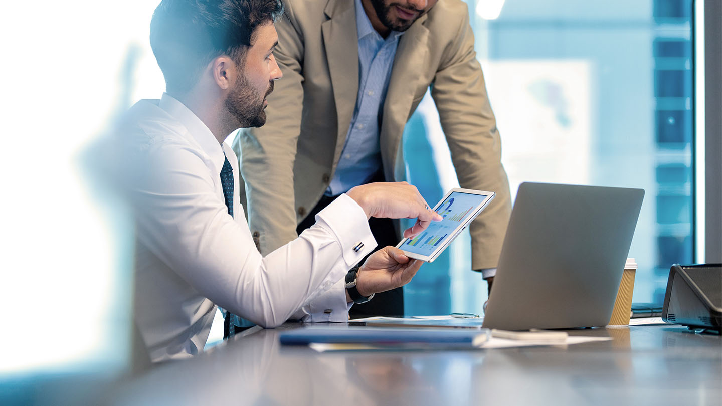 Reviewing figures on a tablet during a meeting
